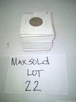 Stack of Buffalo Nickels in protective paper holders, top coin visible labelled 1936 S