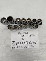 Photo showing 13 large sockets arranged with a labeled note listing sizes on front and back rows.