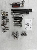 Full set of 31 miscellaneous tools including sockets, ratchet handles, and extensions laid out on a white surface