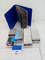 Blue binder opened showing multiple pages of Star Trek trading cards inserted in clear plastic sleeves, with stacks of loose cards arranged neatly in front.
