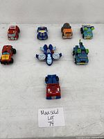 Seven GoBots Transformers Rescue Bots figures arranged on a flat surface, displaying the mix of vehicle and robot forms.