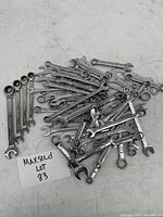 Photo of assorted small wrenches piled together showing mix of open-end, box-end, and ratcheting types in used but good condition.