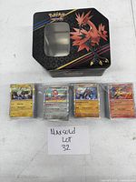 Photo of the Pokémon themed tin storage box and four stacks of yellow border Pokémon cards wrapped in plastic.