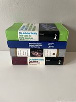 Stacked view of the four hardcover field guides showcasing spines with titles and publisher names.