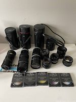 Full view of all lenses, cases, and filters laid out on table showing quantity and condition.