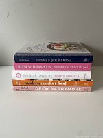Side view showing spines of the five cookbooks stacked horizontally: Make it Japanese, Whiskey in a Teacup, Simply Nigella, Modern Comfort Food, Rebel Homemaker