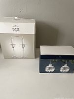 Photo of the Holmegaard Cabernet glass candle holders in the box and the Roseholm clear glass ornaments in their box.