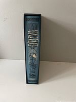 Spine of the book inside the slipcase showing title and illustrations.