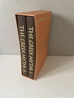 Two hardcover books in slipcase showing spines with title 'The Greek Myths I' and 'The Greek Myths II'