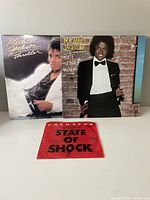 Three vinyl record albums: Michael Jackson's Thriller and Off the Wall, plus Jackson 5 State of Shock album.