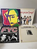 Four vinyl records with original album covers arranged together on a white surface