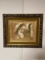 Framed oil painting showing two profile views of an elderly man with curly hair and beard in earth tones.