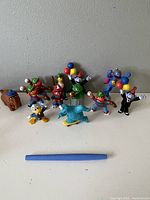 Photo of all figurines from Sesame Street and Donald Duck featuring baseball and balloon themes with various colorful characters.