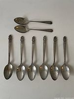 Eight spoons laid out on white background