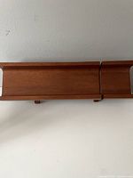 Top view showing the straight elongated section and smaller attached section of the teak bread cutting board.