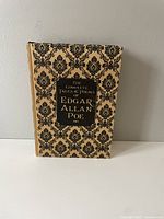 Book standing upright showing front cover with decorative pattern and title.