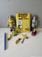 Full lot showing two Inspector Gadget figures, removable arms and chain, Peanuts Roll Call toy, and small Peanuts characters in vehicles.