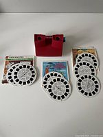 View showing red View-Master viewer and six reels plus two packages with reels inside.