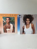 Two Whitney Houston vinyl records with their original album covers showing different images of Whitney Houston.