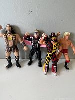 Front view of four vintage wrestling figures with different costumes and poses