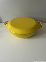 Top view of yellow enamel Dutch oven with lid closed, showing shape and color.