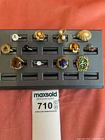 Photo of 11 assorted costume jewelry rings on black display board on red background
