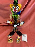 Wide shot of the large clown with two smaller clown figurines beside it.