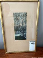 Full view of framed colored photograph showing mat and gold-tone frame with some wear