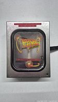 Metal collector's case for Back to the Future Complete Adventures DVD set, artwork depicts flux capacitor and control panel details.