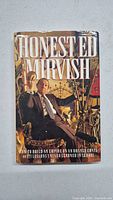 Front cover of the book showing Honest Ed Mirvish seated with eclectic background items and title prominently displayed.
