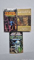 Front covers of three sci-fi paperback books: 'The Norby Chronicles More Army Robots', 'Robot City Suspicion', and 'Norby Through Time and Space'.