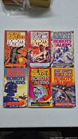 Front covers of 6 Isaac Asimov's Robot City Robots vs Aliens paperback books, showing colorful robot and alien artwork with titles.