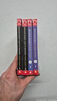 Spine view of four manga volumes showing titles and volume numbers