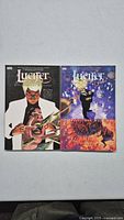Two Lucifer paperback trade paperbacks, side by side on a plain surface showing front covers with Lucifer themed artwork.