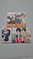 Five Rainbow Days manga books arranged, showing front covers with colorful character art and Japanese text.