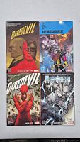 Front covers of four Marvel TPB paperbacks laid out flat: two Daredevil volumes, one Moon Knight, and one Marauders.