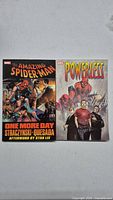 Front cover of Amazing Spider-Man One More Day and Powerless graphic novels side by side.