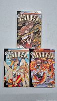 Front covers of three Tsubasa manga books, volumes 0, 1, and 2, featuring colorful anime-style illustrations with characters and fantasy elements.