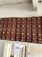 Photo of ten antique William Shakespeare books from Volume I to Volume X, showing leather-bound spines with gold embossing, worn edges and some damage.