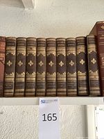 Twelve antique volumes of Irving's Works arranged on shelf showing gilt embossed titles and decorative spine details.