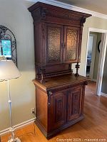 Front view of the complete antique wooden buffet cabinet hutch showing carved details and textured glass doors on upper cabinet.