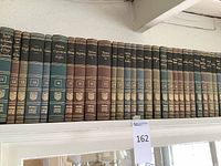 Shelf of Britannica Great Books volumes 12 to 24 featuring titles like Euclid, Archimedes, Virgil, and Manilius in hardcover with cloth-bound spines in brown, green, and black.