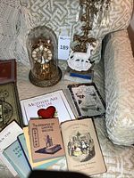 Overview of lot showing clock, candelabra, and assorted books