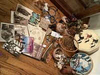 Wide shot of entire lot on wooden floor including drums, dreamcatchers, pottery, books, photos, and sculptures