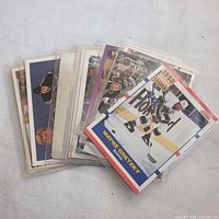 Pile of ten hockey cards in protective sleeves, showing various players and designs with one prominent Wayne Gretzky card visible