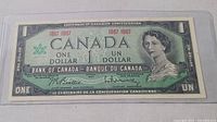 Front view of 1967 Canadian one dollar bill featuring Queen Elizabeth II and centennial commemorative design.