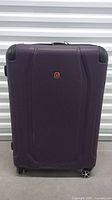 Front view of purple Swiss Gear suitcase showing textured shell and spinner wheels