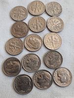 Fifteen US dimes arranged showing obverse and reverse sides, close-up to identify dates and design details.