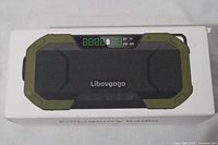 Top view of the boxed emergency radio showing the front speaker panel, buttons, and display.