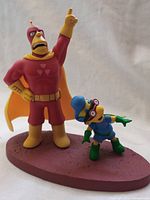 Front view showing Radioactive Man pointing upwards and Fallout Boy posed beside him on base.